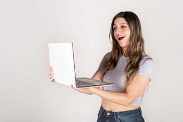 Studio portrait on white background of blonde woman holding a computer looking at the screen happy...