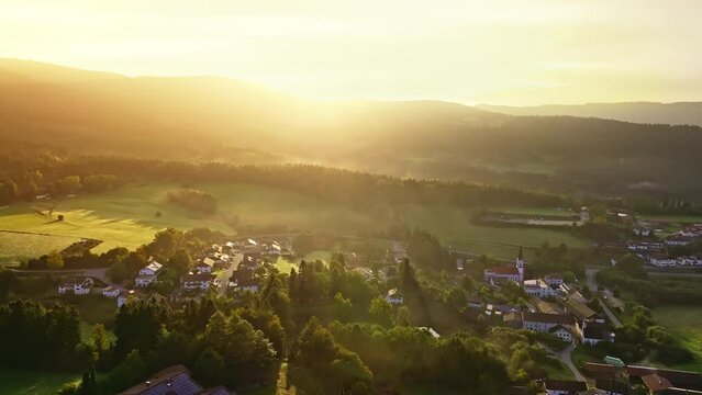 Drone approaches small Bavarian village hidden by fog. Beautiful early sunshine