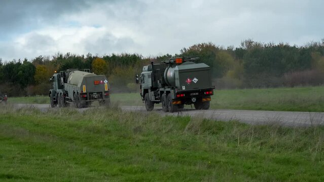 A convoy of British army utility vehicles including Oshkosh Close Support Tanker, M.A.N. HX58 unit support tankers, and MAN HX77 8x8 EPLS and covered back. Wiltshire UK