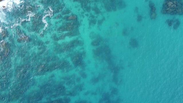 Aerial view of the movement of waves on a clear blue sea