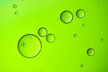 Macro shot of oil bubbles texture on a green background