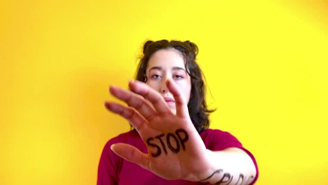 Video of close-up of a woman's hand with the word stop written on it. Concept of struggle and equality of women's rights. Women's day.