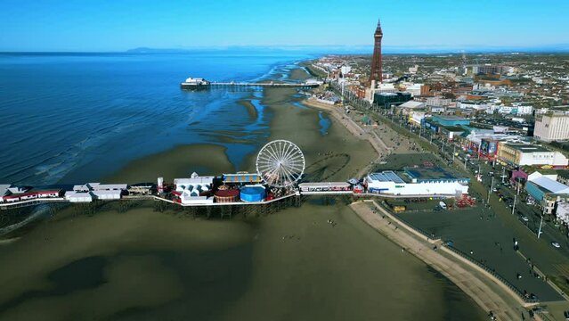 Aerial video of the ferrys wheel and pier in Blackpool during the sunny day