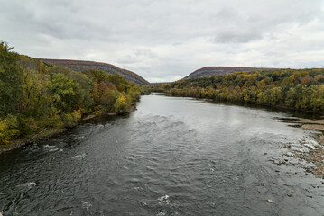 Fototapeta premium delaware water gap view from viaduct (autumn with fall colors, trees changing) beautiful landscape Pennsylvania and new jersey border (river, sky, trees, mountains) travel, hiking, walking, scenic