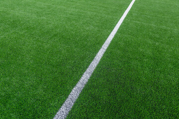 Green synthetic grass sports field with white line shot from above. Soccer, hurling, lacrosse,...