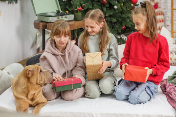Children preteen opening magic Christmas gift at home. Merry Christmas and Happy Holidays.