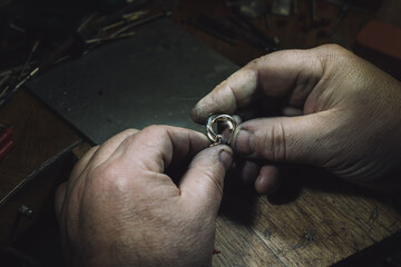 master of jewelry with an earring. Working desk for craft jewelry making with professional tools....