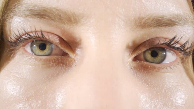 Close-up woman opens her hazel eyes.