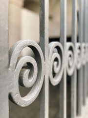 Side profile view of an ornate wrought iron gate with a swirl pattern.