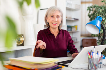 Successful mature business woman using laptop at workplace