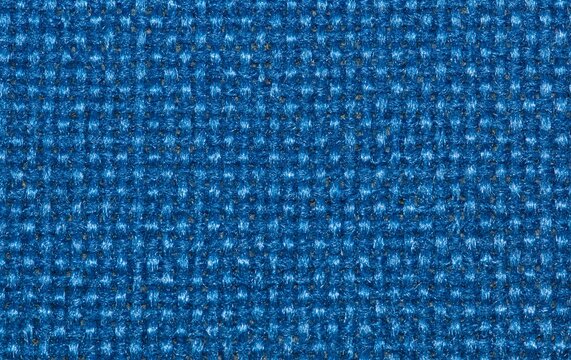 Solid royal blue color swatch of woven fabric on upholstery made from polyester, rayon or nylon material with macro details.