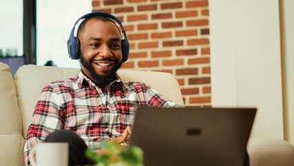 Gamer watching online streaming videogame competition, rooting for favourite team white sitting at...