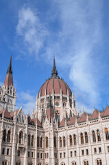 Fototapeta na wymiar Vertical shot of the Hungarian Parliament Building on blue cloudy sky background