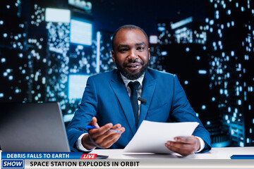 Breaking news about orbit explosion, debris falling from the sky and floating around the atmosphere. Man presenter creating newscast on space station bursting to flames, night show host. - obrazy, fototapety, plakaty