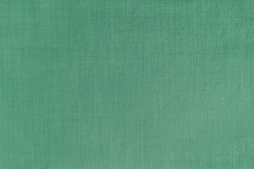 Texture background of green linen fabric. Textile structure, cloth surface, weaving of natural cotton fabric closeup, backdrop, wallpaper.