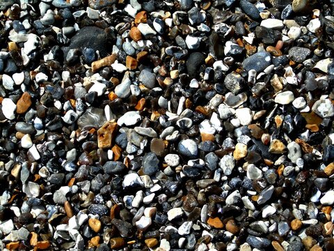 Top view of cute colorful wet pebbles on the beach