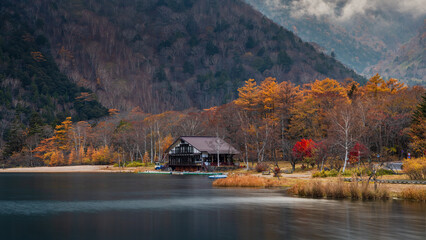 Cabin House by Lake and Mountains in Autumn