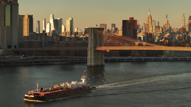 Drone shot of a barge passing through New York City during an Autumn sunset