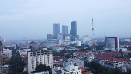 Morning cityscape of Surabaya town, downtown and skyscrapers in cloudy weather in rainy season