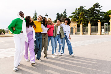 Multi ethnic group of joyful beautiful women having fun together outdoors. Diverse female friends...