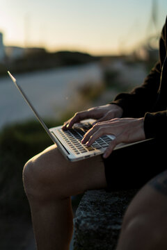 Toma detalle de port&aacute;til en el regazo de una persona en la calle mientras trabaja