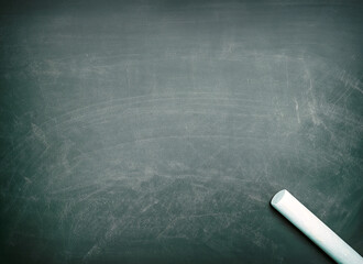 Chalkboard with a piece of chalk on the lower right corner