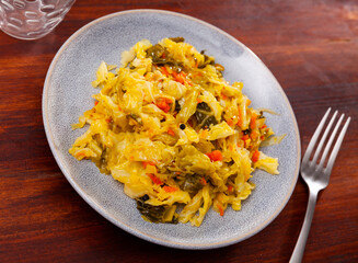 Stewed cabbage served on wooden table. Portion of braised vegetables.