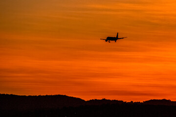Avion en vol dans un ciel orange au coucher de soleil 