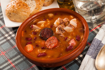 Traditional Asturian rich beans stew with pork shoulder, morcilla and chorizo (Fabada) served in...