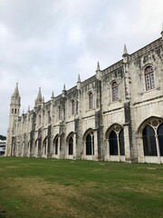 Fototapeta premium Vertical shot of the medieval Jeronimos Monastery in Portugal against the cloudy sky
