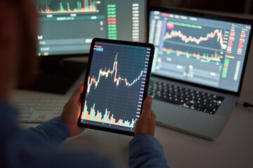 Businessman trader investor broker holding tablet computer analyzing charts bank account market rate global indexes online forecast on stock exchange digital finances trade platform. Close up view.