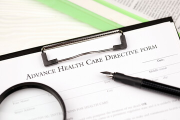 Advance health care directive blank form on A4 tablet lies on office table with pen and magnifying glass close up
