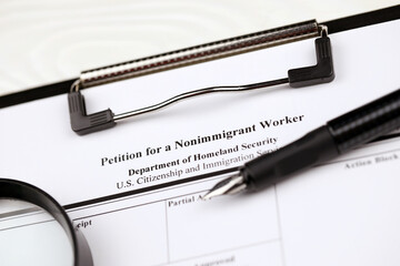 I-129 Petition for a nonimmigrant worker blank form on A4 tablet lies on office table with pen and magnifying glass close up