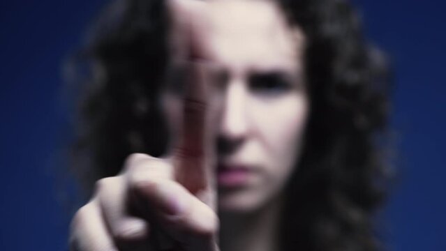 Upset woman pointing finger to camera saying NO by waving in rejection. Close-up of negative body language gesture