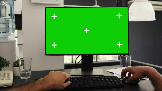 POV of young man at office desk checking greenscreen and isolated chromakey template, solving business operations. Manager sitting at desk looking at blank mockup display. Tripod shot.