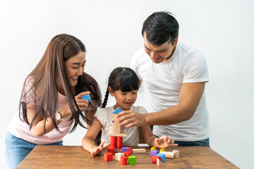 Portrait of enjoy happy love asian family father and mother with little asian girl smiling activity learn and skill brain training play with toy build wooden blocks board education game at home