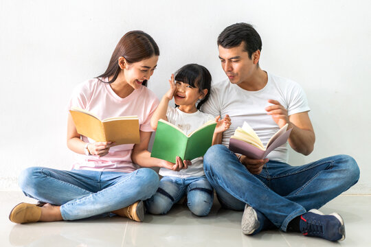Portrait enjoy happy love asian family father and mother with little asian girl learn and study.Mom and dad with asian young girl holding book make homework in homeschool at home.Education