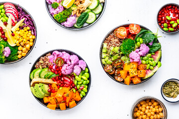 Vegan buddha bowls set with pumpkin, quinoa, tomatoes, spinach, avocado, radish, soybeans, edamame, tofu, cabbage and seeds, white background, top view. Autumn or winter winter menu, slow comfort food