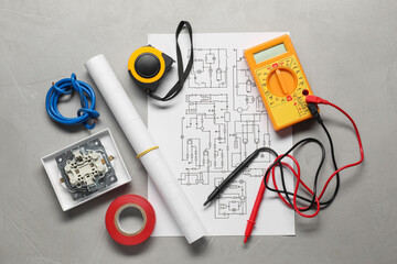 Wiring diagram, wires and digital multimeter on light grey table, flat lay