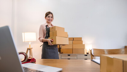 Portrait of starting a small business SME business owner Female entrepreneur working on merchandise boxes Receipts and checks online orders to prepare boxes for seller to customers.