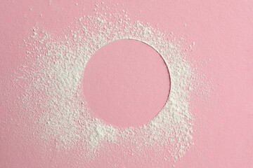Frame made of rice loose face powder on pink background, top view. Space for text