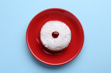 Hanukkah donut with jelly and powdered sugar on light blue background, top view