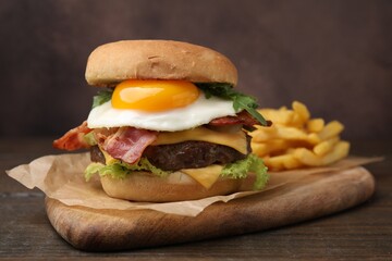Delicious burger with fried egg on wooden table, closeup