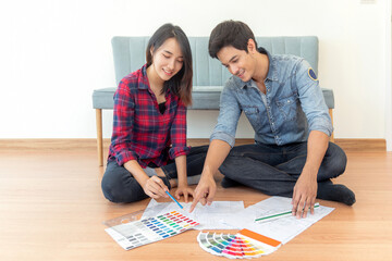 Asian couple just new married husband and his wife design and select color for new house