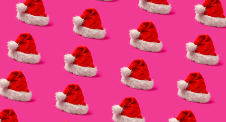 Many Santa hats on pink background. Pattern for design