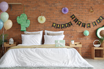 Interior of bedroom decorated for birthday with pinatas, balloons and garland