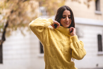 Fototapeta premium Beauty and charm: beautiful latino brunette model with a colorful fashion look in a urban street posing