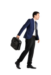Young businessman with briefcase walking on white background