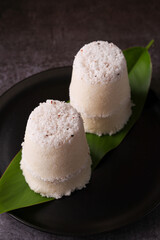 Popular South Indian breakfast puttu / pittu made of rice flour and coconut with banana and kadala curry, Kerala breakfast, India. Bamboo puttu prepared in steam