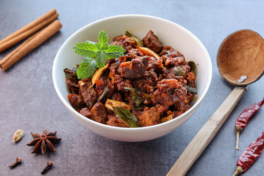 Kerala style beef or Mutton dry fry. delicious spicy Beef fry in clay pot . beef curry for ghee rice, kappa, appam, parotta, puttu, bread and chappathi, beef roast. Indian cuisine .